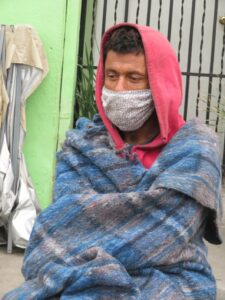 Man wearing mask and blanket